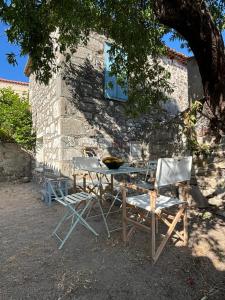 a table and two chairs sitting next to a building at Tsagalo House in Skala Eresou