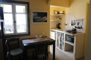 a kitchen with a table and a stove top oven at Panormos Apartments in Panormos