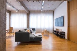 uma sala de estar com um sofá e uma televisão em NEW! San Mames em Bilbao