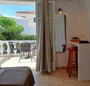 een slaapkamer met uitzicht op een balkon met een spiegel bij Villa Margarita in Spetses