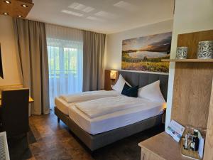 sypialnia z łóżkiem i obrazem na ścianie w obiekcie Dei Hotel Schönblick w mieście Velden am Wörthersee