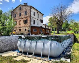 an old building and a boat in front of a house at La Cascina di Muttley in Doglio