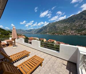 a balcony with two benches and a view of the water at House with big terrace and beautiful sea view in Kotor