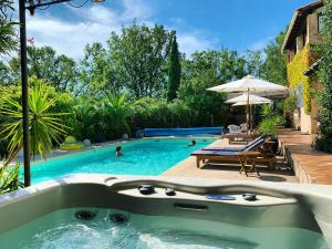 a swimming pool with a tub in a backyard at Villa La Rose des Vents in Tourrettes +30 photos