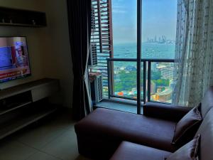 een woonkamer met een bank en een groot raam bij 2 Bedrooms sea view condo in Pattaya South