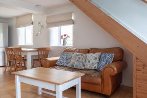 a living room with a couch and a table at Cosy Beachside Cottage in Bigbury