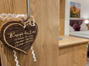 un corazón de madera colgando de una puerta en una cocina en Dei Hotel Schönblick en Velden am Wörthersee