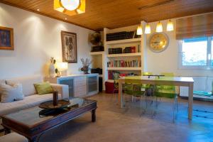 un soggiorno con divano, tavolo e orologio. di Bayside House by Libracomm a Artemida