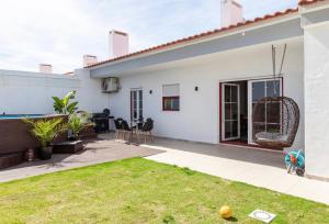 ein weißes Haus mit einer Terrasse und Gras in der Unterkunft Casa do alqueva in Reguengos de Monsaraz