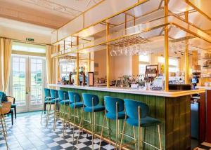 un bar con sillas azules en un restaurante en The Astbury Golf And Lodge Resort, en Bridgnorth