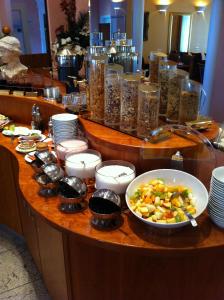 a buffet with bowls and plates of food on a table at Apartment Hotel KRAL - BUSINESS HOTEL & SERVICED APARTMENTS in Erlangen