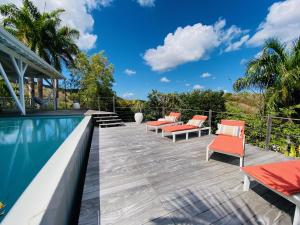 une terrasse avec des chaises et une piscine dans l'établissement Rev Papa Mwen, au Diamant