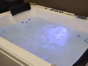 a bath tub filled with lots of blue water at Le Suite di Magda Relax & Rooms in Polignano a Mare
