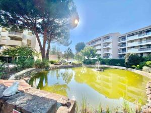 a pond with a fountain in the middle of a building at Appartement climatisé à 800m de la plage in Fréjus