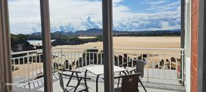 a balcony with a table and chairs and a view of a beach at Hotel Benimar in Isla
