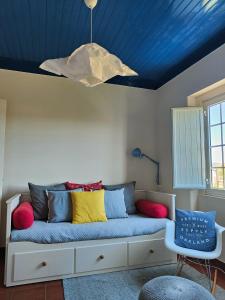 um sofá num quarto com um tecto azul em Flat 23 em Bombarral
