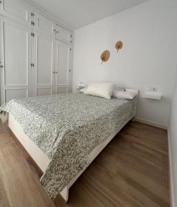 メディナ・シドニアにあるHerrete Roomsの白いベッドルーム(大型ベッド1台、掛け布団付)