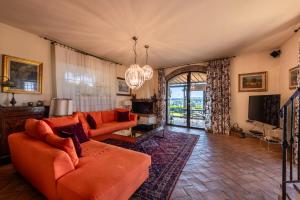 sala de estar con sofá naranja y TV en Charming Country Retreat with stunning views en Impruneta