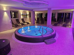 a hot tub in the middle of a room with chairs at Dei Hotel Schönblick in Velden am Wörthersee