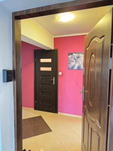 a room with a door and a pink wall at Apartment in the center of Elk in Ełk