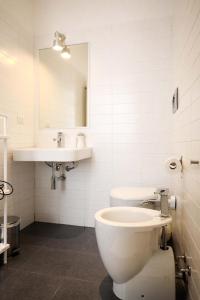 a bathroom with a toilet and a sink and a mirror at I'MC IoAMoCagliari in Cagliari