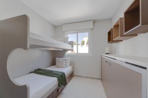 une petite cuisine avec des murs blancs et des comptoirs blancs dans l'établissement Nova SuperBeach 38, à Gran Alacant 3 autres photos