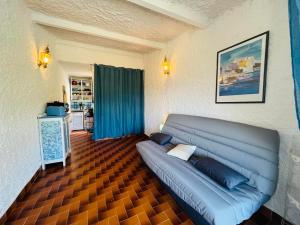 a living room with a blue couch in a room at Studio Cocody 49 LUMIO in Lumio