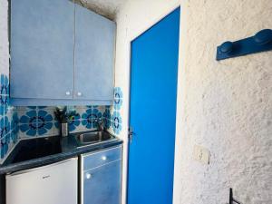 a kitchen with a sink and a blue door at Studio Cocody 49 LUMIO in Lumio +7 photos