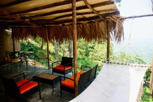 a porch with chairs and tables and a hammock at NOMAD Domes Sky Watching at Jarabacoa in Jarabacoa
