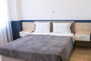 a bedroom with a bed with two pillows at Guest House Gerasimovi in Elena