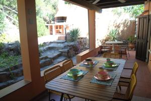 a wooden table and chairs on a patio at Cala Sinzias beach house with stunning views in Costa Rei