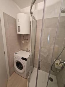 a shower stall with a washing machine in a bathroom at Apartman Emily2 Dramalj in Dramalj