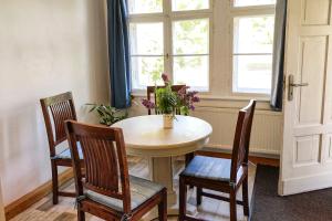 a table and chairs with a vase of flowers on it at Ferienwohnung zur Pferdekoppel in Bömitz