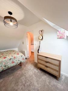 a bedroom with a bed and a dresser at Maison bretonne rénovée proche bourg et plages in Plouguerneau