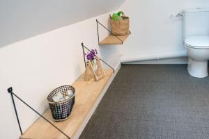 a bathroom with a toilet and a basket of flowers at Maison bretonne rénovée proche bourg et plages in Plouguerneau +43 photos