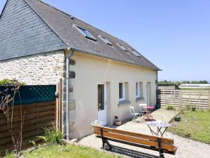 a small stone house with a bench and a table at Maison bretonne rénovée proche bourg et plages in Plouguerneau