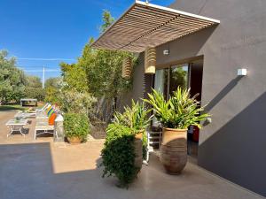 a patio with potted plants in front of a house at Villa Jardins D'Isa in Marrakech