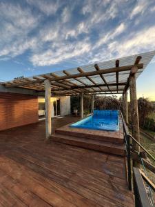 un pergolato sopra una piscina su una terrazza di DARMI a Villa Serrana