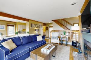 ein Wohnzimmer mit einem blauen Sofa und einer Küche in der Unterkunft Samoset Condo on Lake Winnipesaukee in Gilford