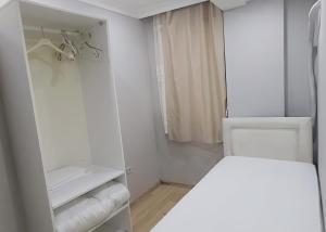 Habitación blanca con cama y armario en Hane Apart, en Estambul