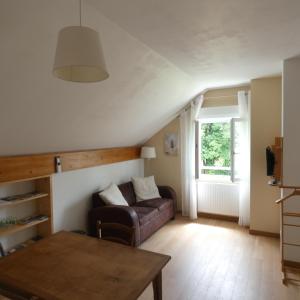 ein Wohnzimmer mit einem Sofa und einem Tisch in der Unterkunft les iris in Villevieux