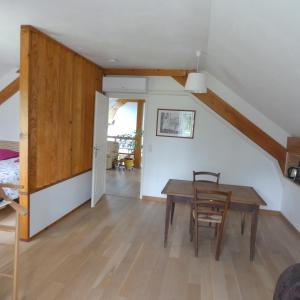 ein Wohnzimmer mit einem Holztisch und Stühlen in der Unterkunft les iris in Villevieux