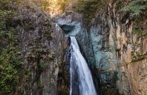 a waterfall on the side of a cliff at NOMAD Domes Sky Watching at Jarabacoa in Jarabacoa +5 photos
