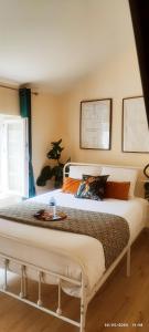 um quarto com uma grande cama branca num quarto em La Green Room em Poitiers