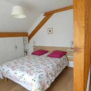 1 dormitorio con 1 cama con 2 almohadas rojas en les iris, en Villevieux