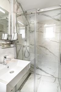 a white bathroom with a shower and a sink at Sleep Inn Düsseldorf in Düsseldorf