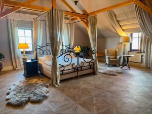 ein Schlafzimmer mit einem Himmelbett und einem Stuhl in der Unterkunft Park Hotel Popovicky in Popovičky