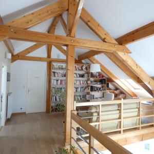 een kamer met houten balken en boekenplanken bij les iris in Villevieux