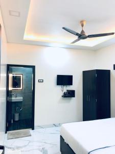 a bedroom with a bed and a ceiling fan at Sameena Guest House in Panchgani +29 photos