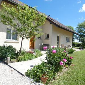 uma casa com flores cor-de-rosa em frente em les iris em Villevieux